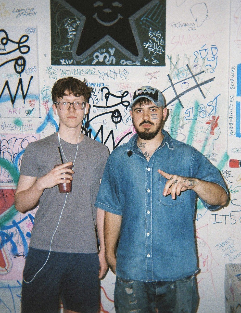 Owen and Austin Babbitt in front of a graffiti-covered wall